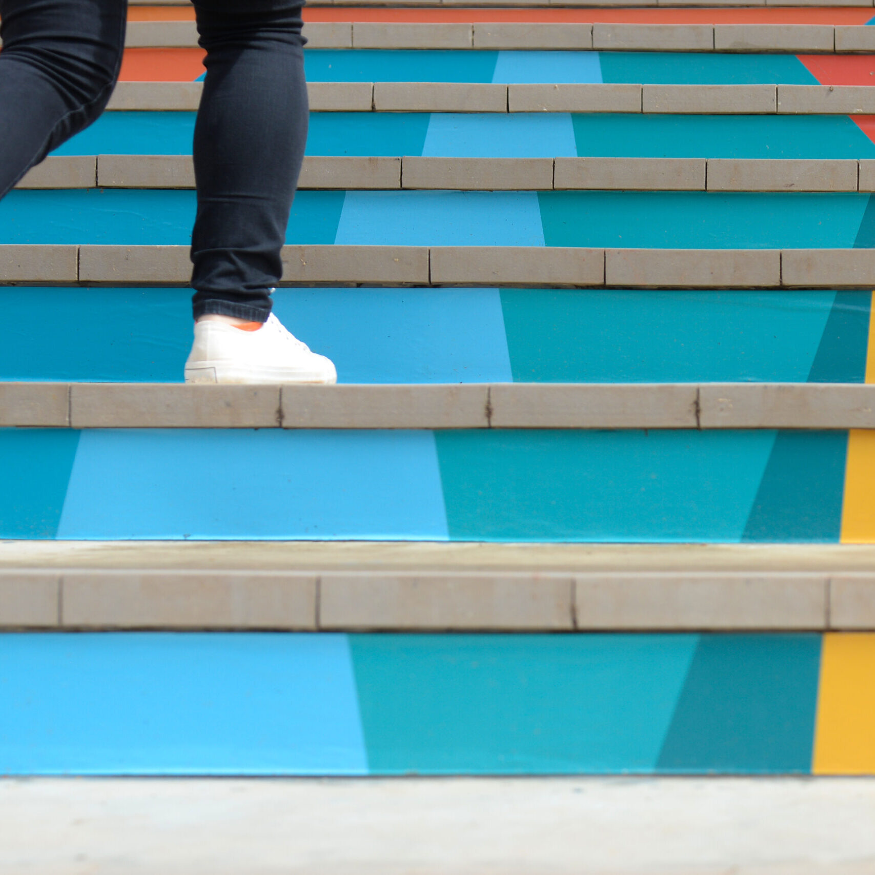 1-on-1 Coaching Program represented by Feet Going up Multicolored Steps Our 1-on-1 Coaching Program